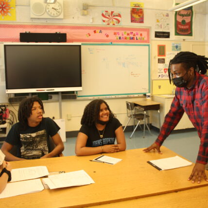 Futures and Options staff teaches students in a school