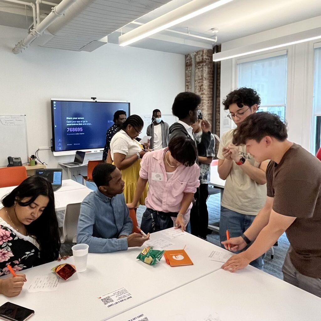 Students gather around a desk in the workshop space