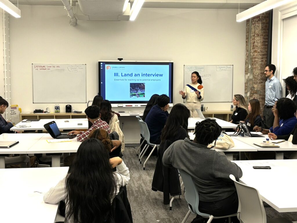 A Junior Board member presents to a group of alumni