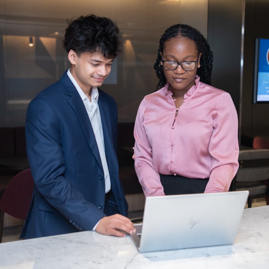 Two students look at a laptop together